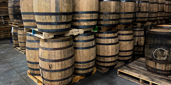 Head bung whiskey barrels stored vertically and stacked on pallets