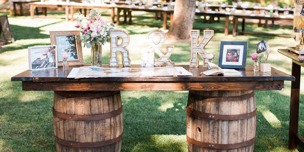 Wood slab table at wedding using barrels as supports