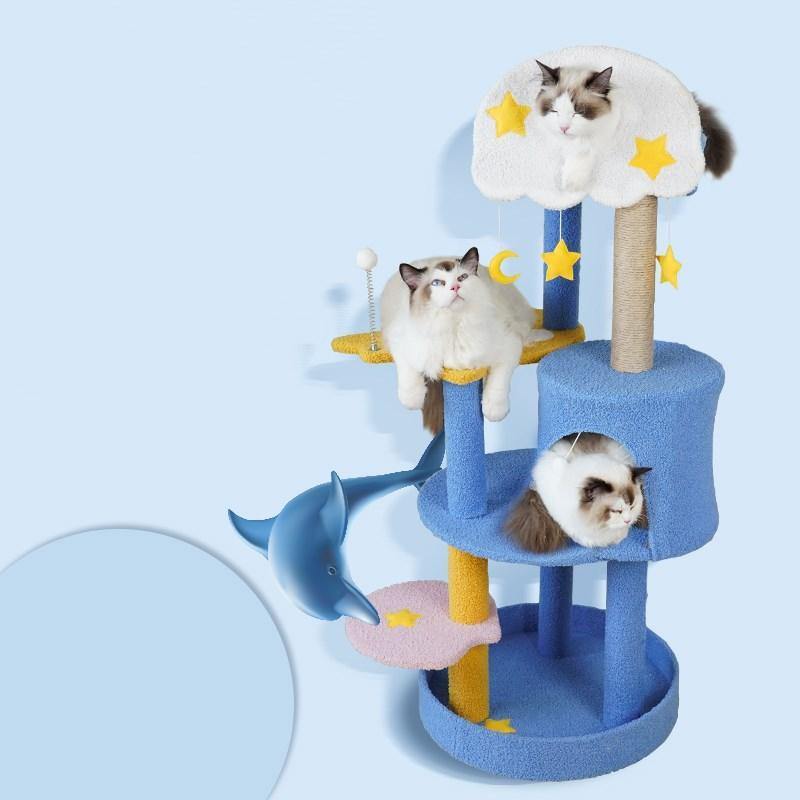 A black and white fur cat climbing on a blue and yellow cat tree that is designed with clouds and stars