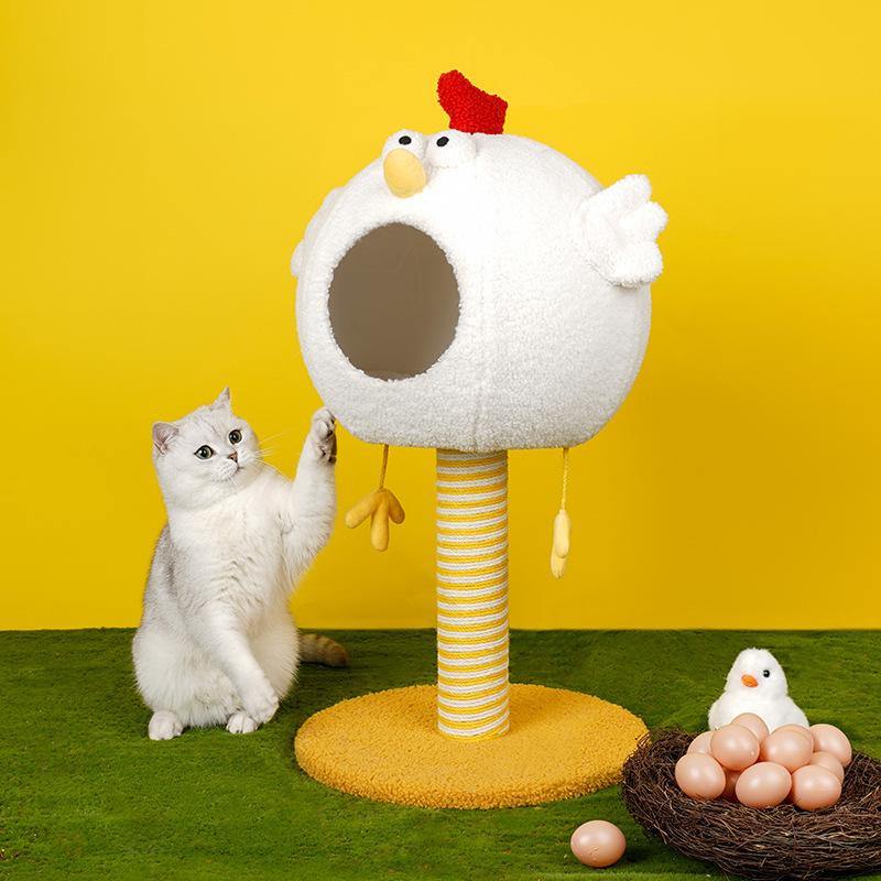 A white cat beside a chicken cat condo with a scratching post