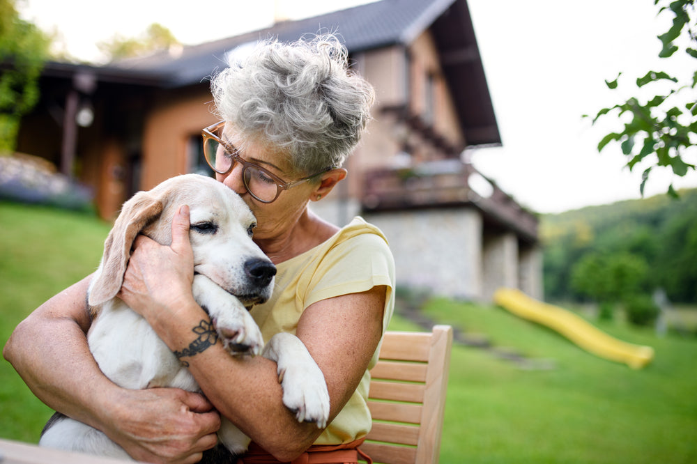 Senior woman cuddling with her dog