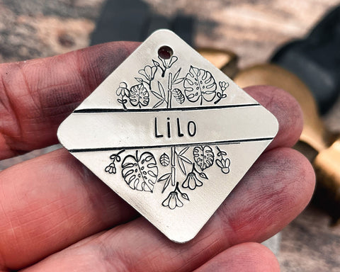 square hand-stamped dog tag with leaf and flower design