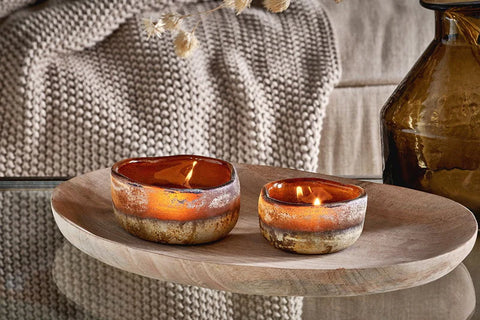 Nkuku Janka amber glass tealight holders on wooden bench