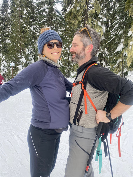 Sarah and Jared bump bellies in a snowy setting