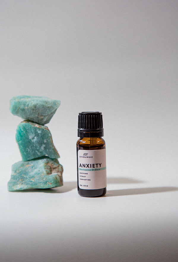 Aromawest Anxiety Essential Oil Blend next to green rocks.