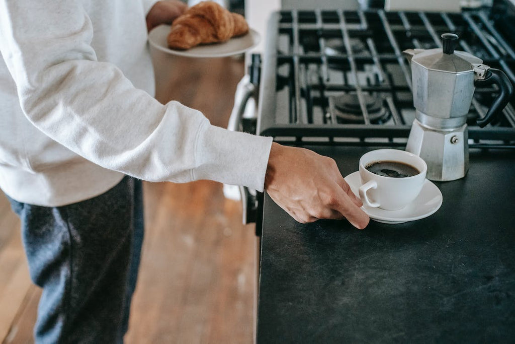 image of a moka pot with a cup of coffee