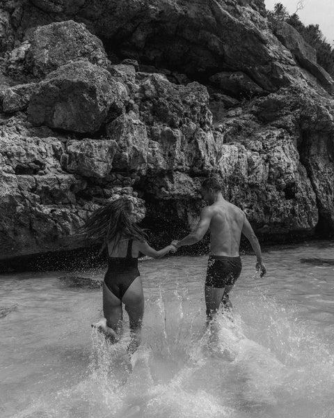 Man and women running and playing in the water on vacation at Calo Del Moro, Mallorca for Lauren Bentley Swimwear