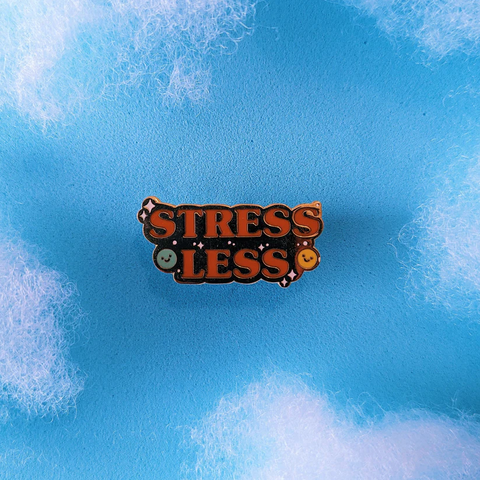 mental health gifts - gold enamel pin that says "stress less"