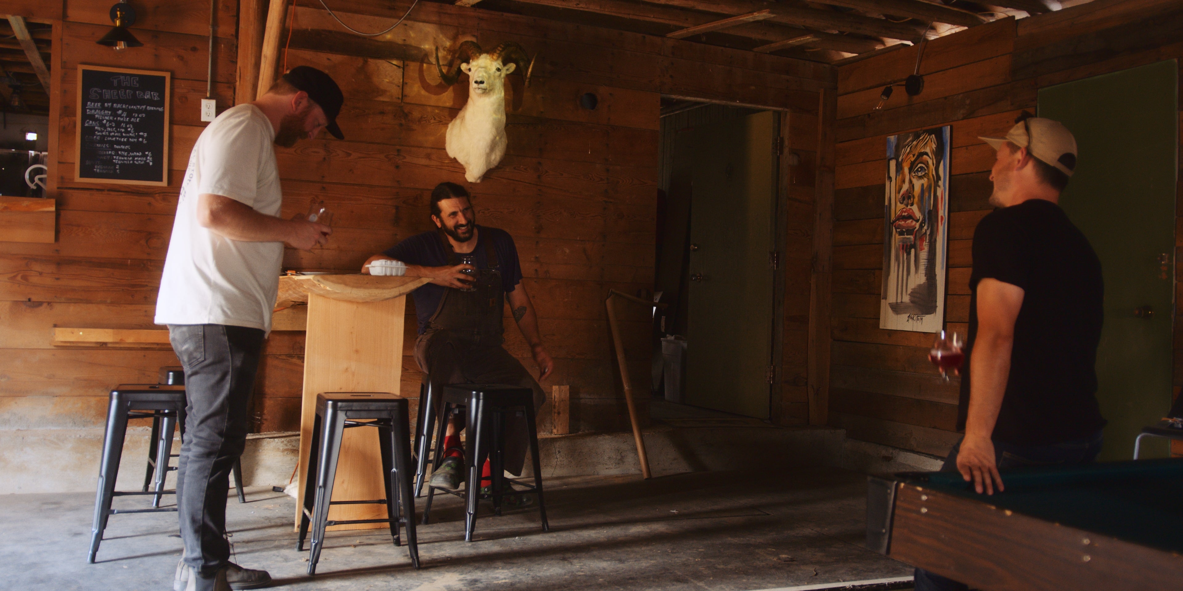 Jordan, Matt, and Isaiah all sharing a beer in the hop barn
