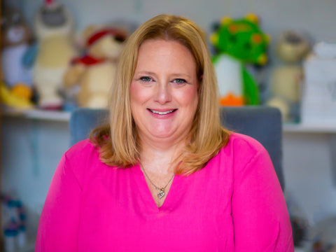 woman with blonde hair wearing a bright pink shirt 