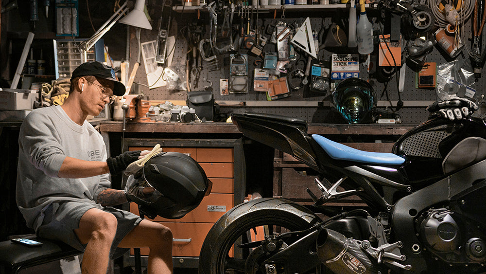 rider cleaning his motorcycle helmet