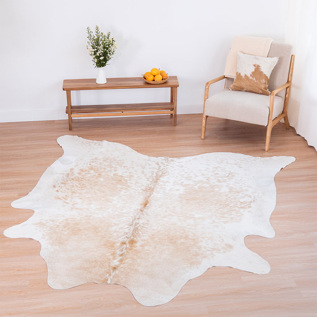 Palomino and White Cowhide Rug on a light wood floor in a bright room.