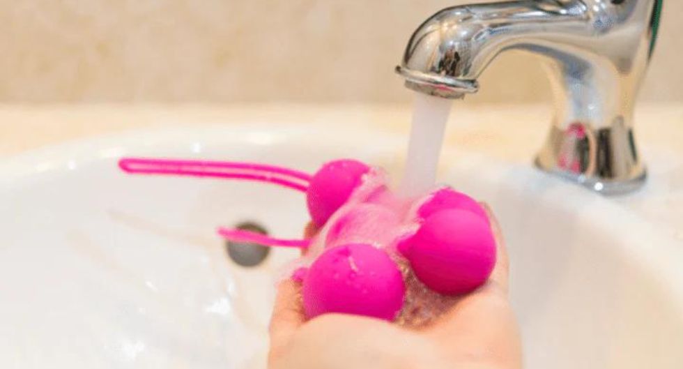 sex toy igienizzato sotto acqua corrente per mostrare un giusto uso del vibratore