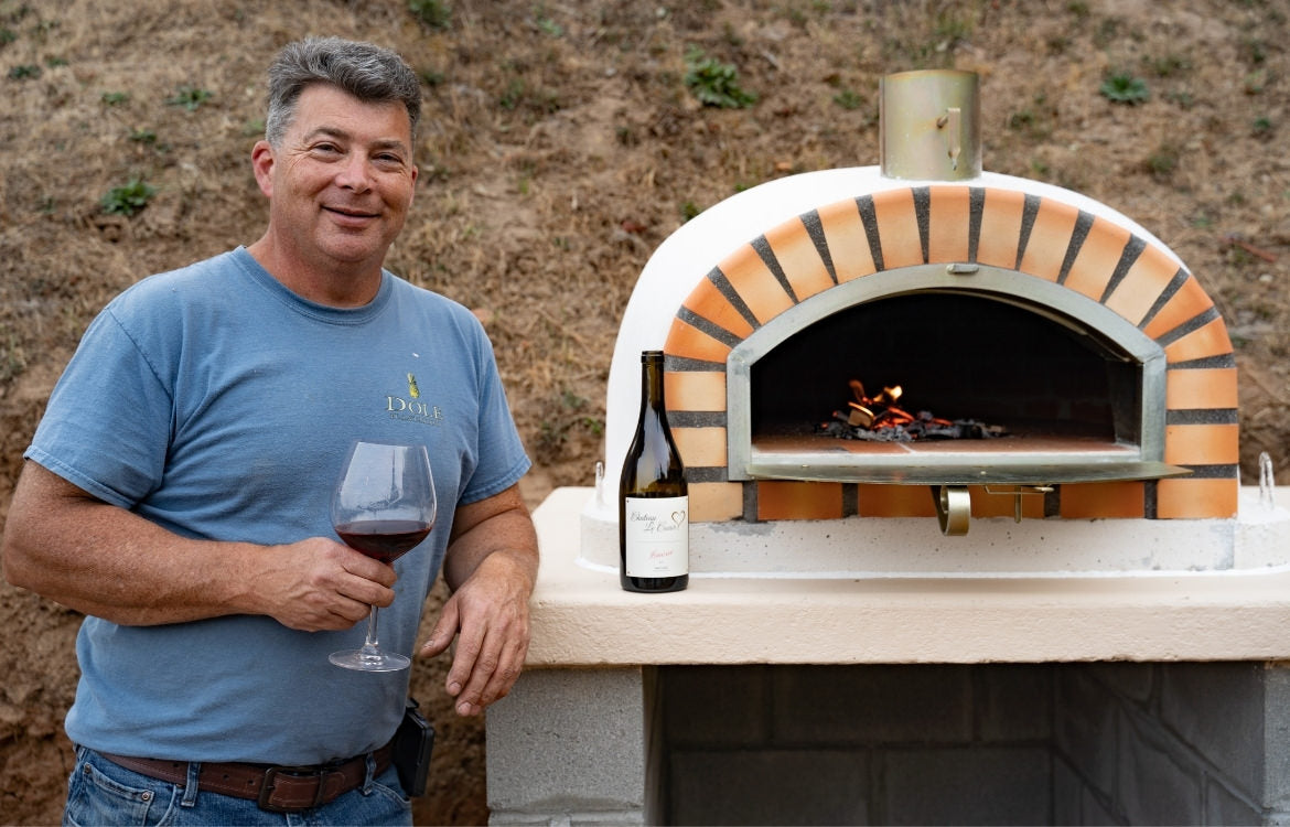 Man Drinking Wine Next To EuroFlame Wood-Fired Pizza Oven