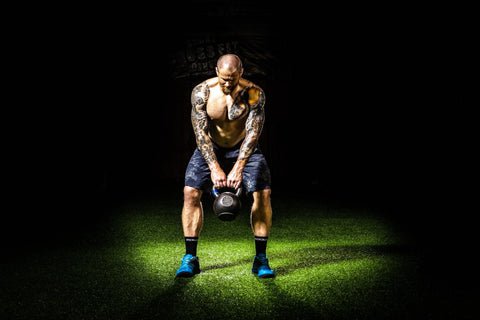 Man doing back fat exercises with Kettlebell