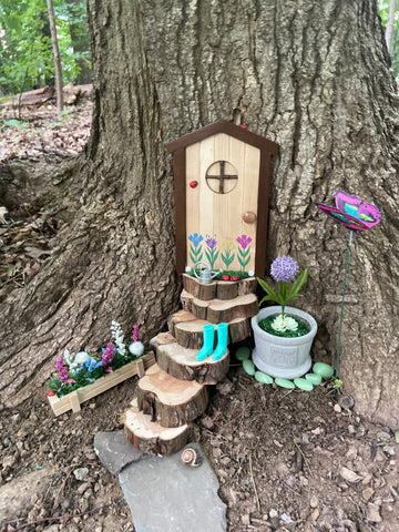 Fairy door with steps, flowers and other decorations.