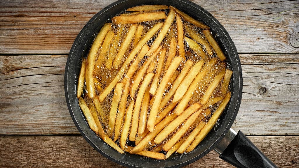 Cuisson de frites de pommes de terre dans de l'huile d'olive