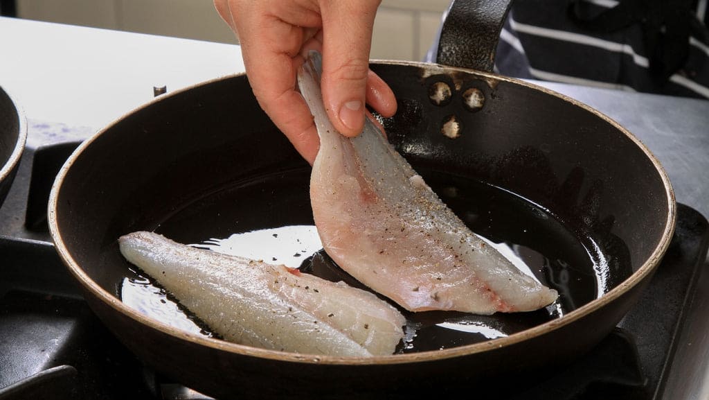 Cuisson à la poêle de deux filets de poisson à l'huile d'olive