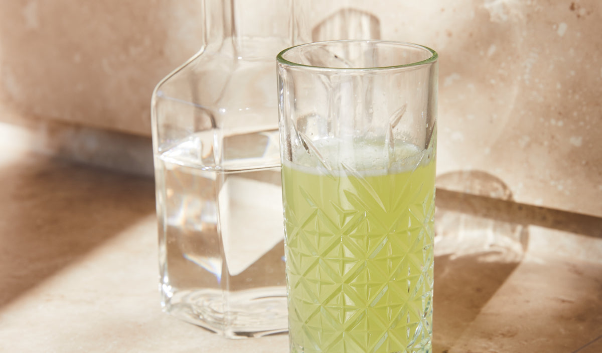 Carafe and glass of Yuzu + Finger Lime Collagen Elixir