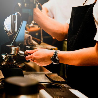 Person making coffee at a coffee machine