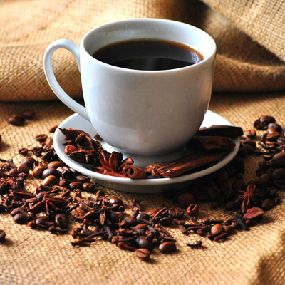 Cup of coffee surrounded by coffee beans 