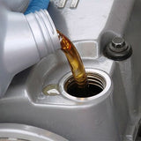 automotive liquid being poured into silver container