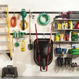 ladder hoses wheel barrow and other outdoor equipment hanging on wall