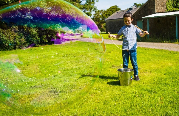 Un enfant faisant des bulles géantes avec le kit Dr Zigs.
