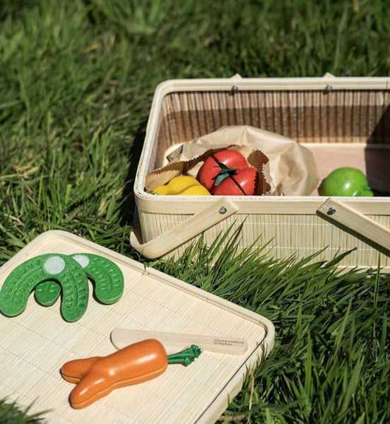 Jouets de légumes en plastique placés à l'intérieur d'un buecket de pique-nique.