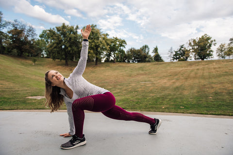 Kayla Hansmann in outside field in yoga, warrior stretch pose