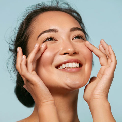 woman smiling while holding her face