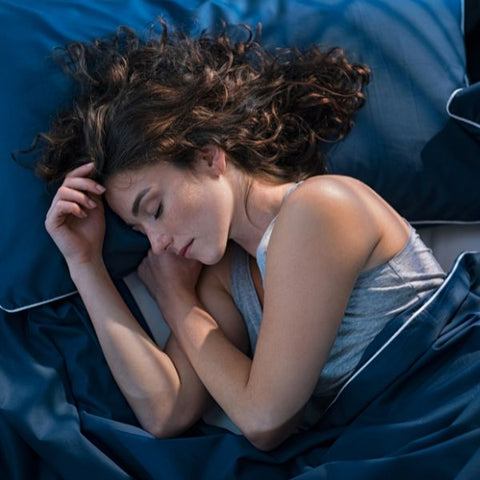Woman with curly hair sleeping on silk covered pillow