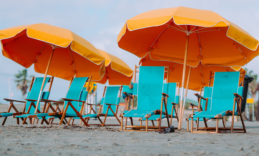 blue deckchairs and orange umbrellas on beach