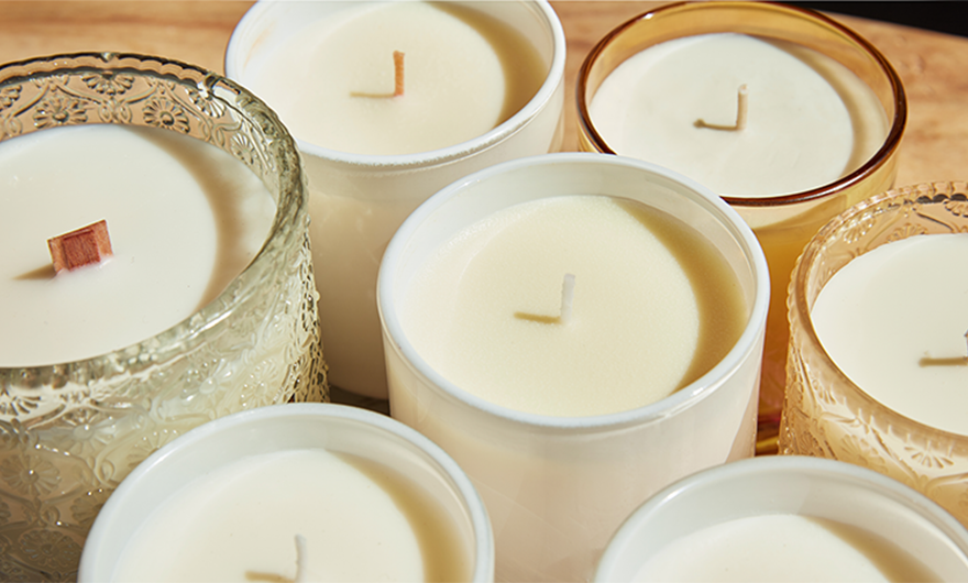 Close-up of unlit white candles in glass jars