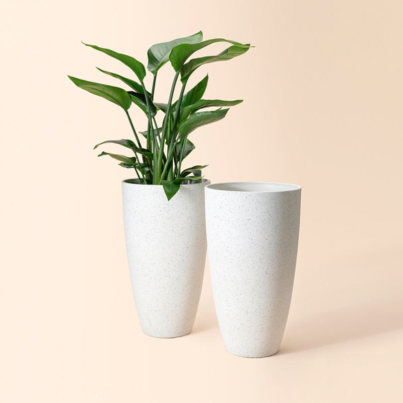A set of two white tall pots with speckles, made of recyclable plastic and stone powders.