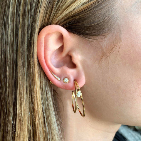Jade Trau gold and diamond earrings on woman's ear 