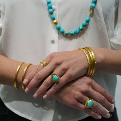 woman wearing gold and turquoise jewelry