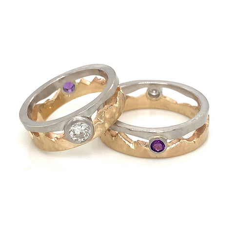 two tone metal wedding bands with mountain ranges cut out with diamonds and amethysts for bride and groom