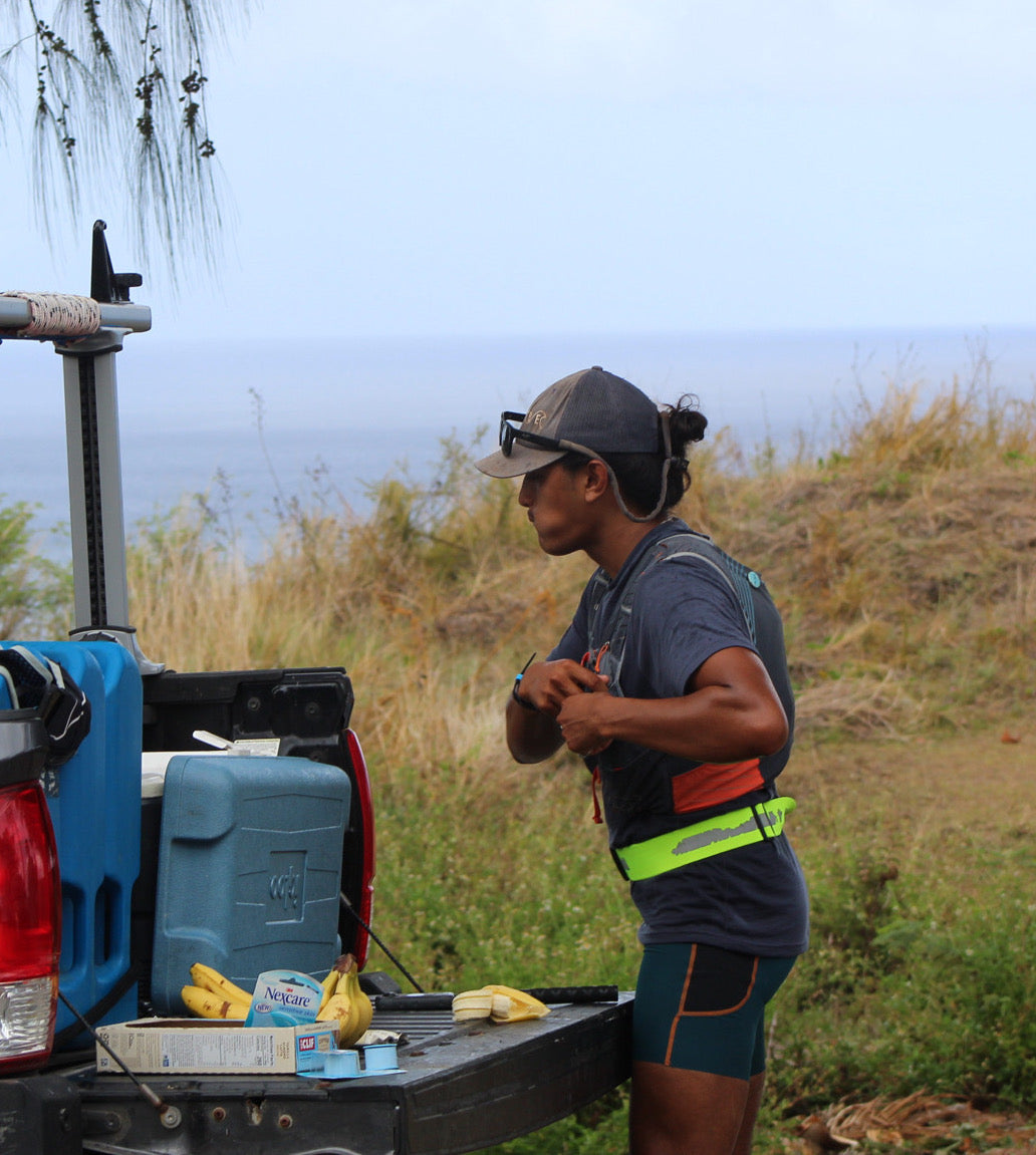 Dillon Quitugua refuels in the back of a pickup truck during his 100 mile run
