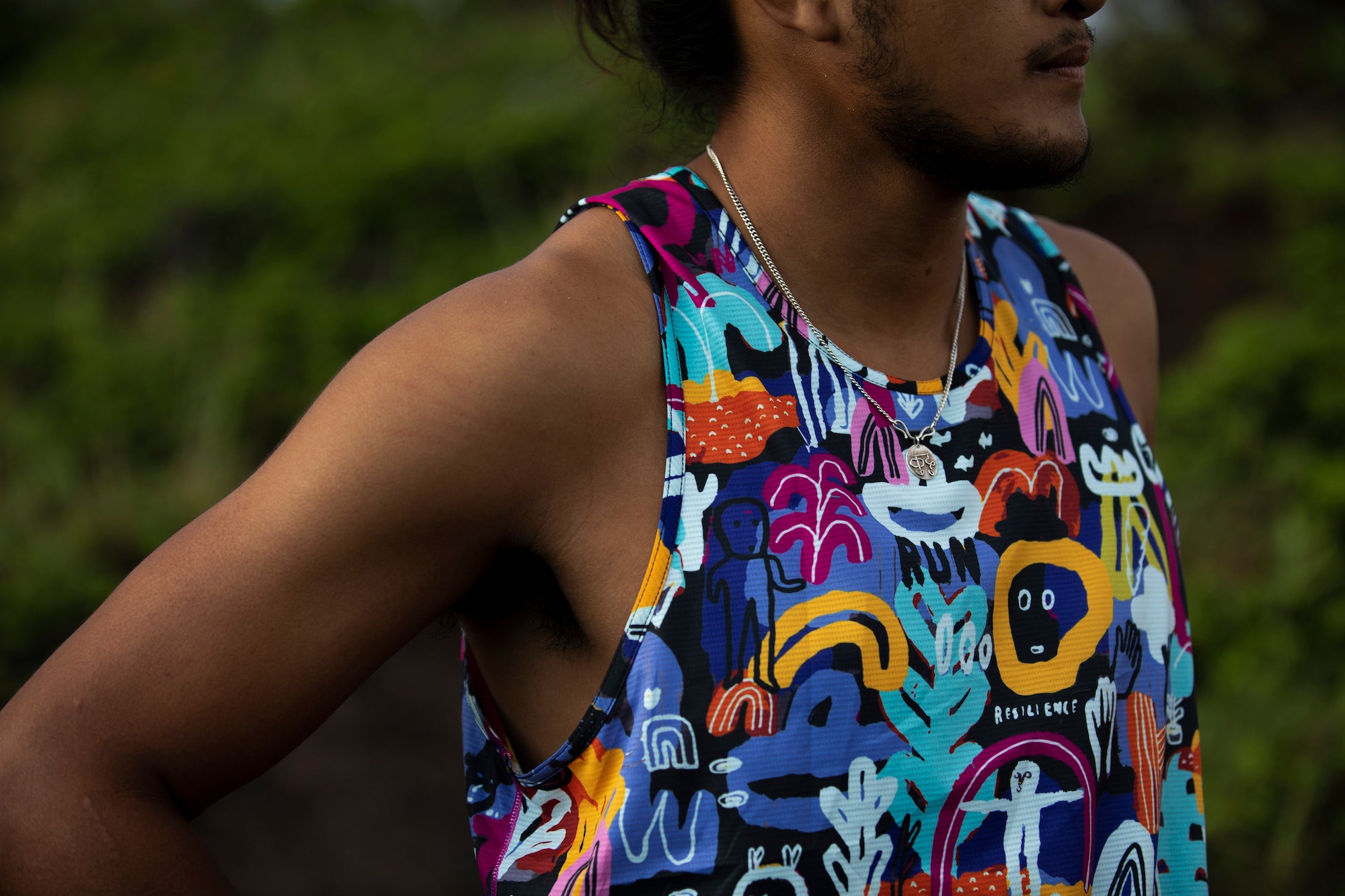 Man wearing Mt. Merapi print Helio Tech Tank with lush background.