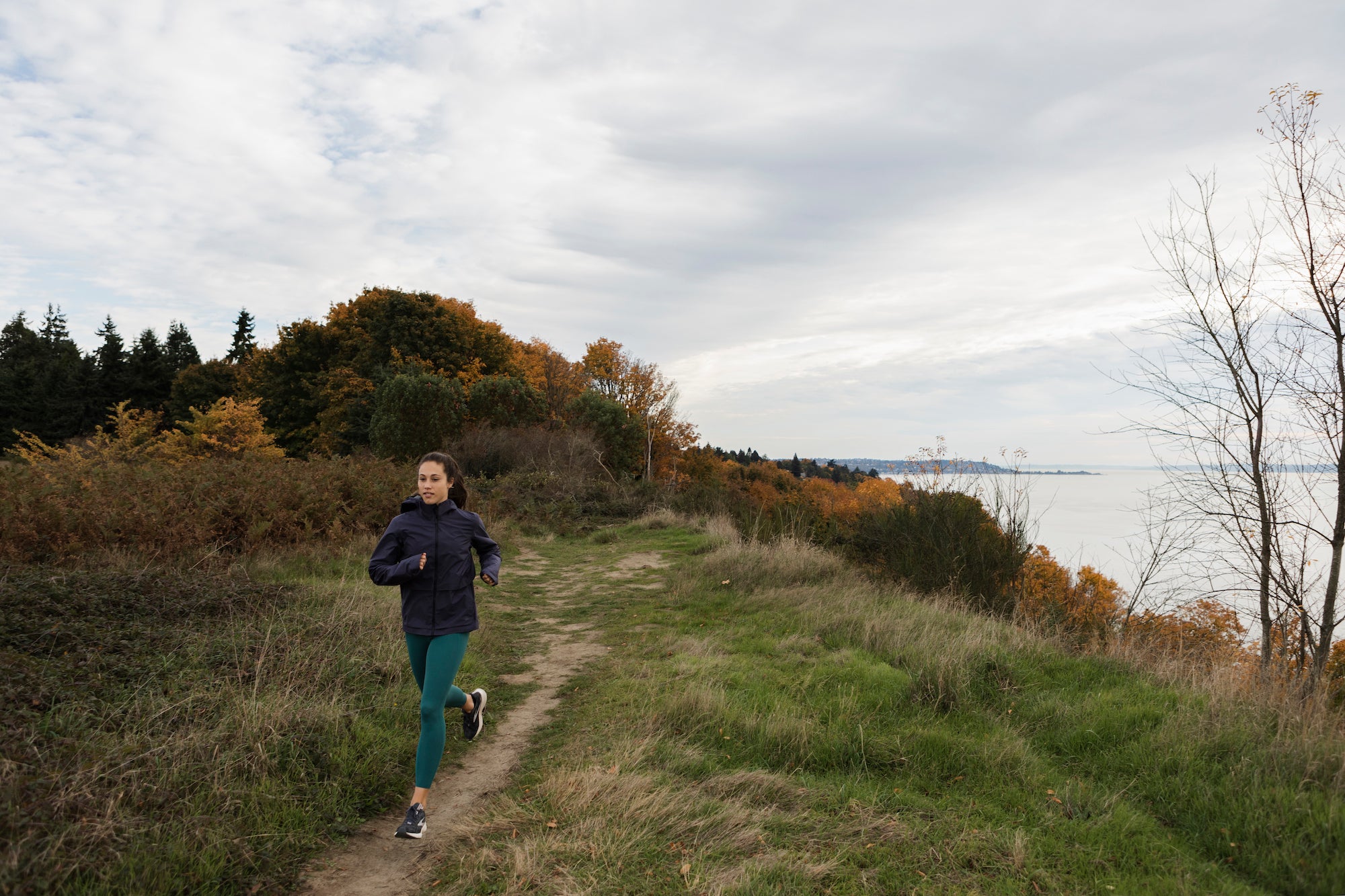 Justine runs along a thin trail along the coast