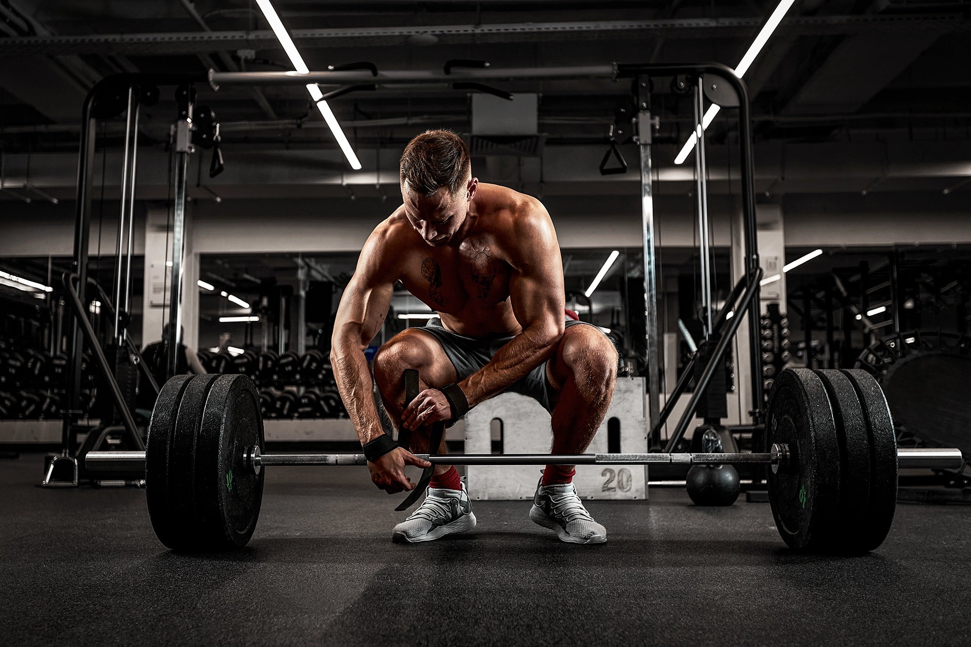 Guy getting ready to do a deadlift in a dark gym