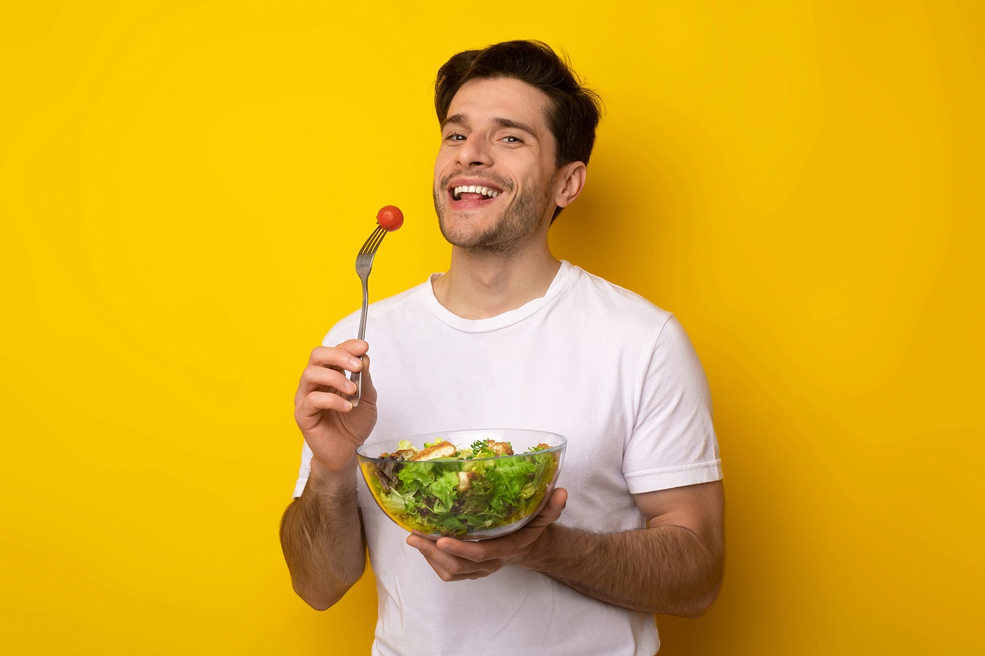 Man holding a salad bowl and smiling