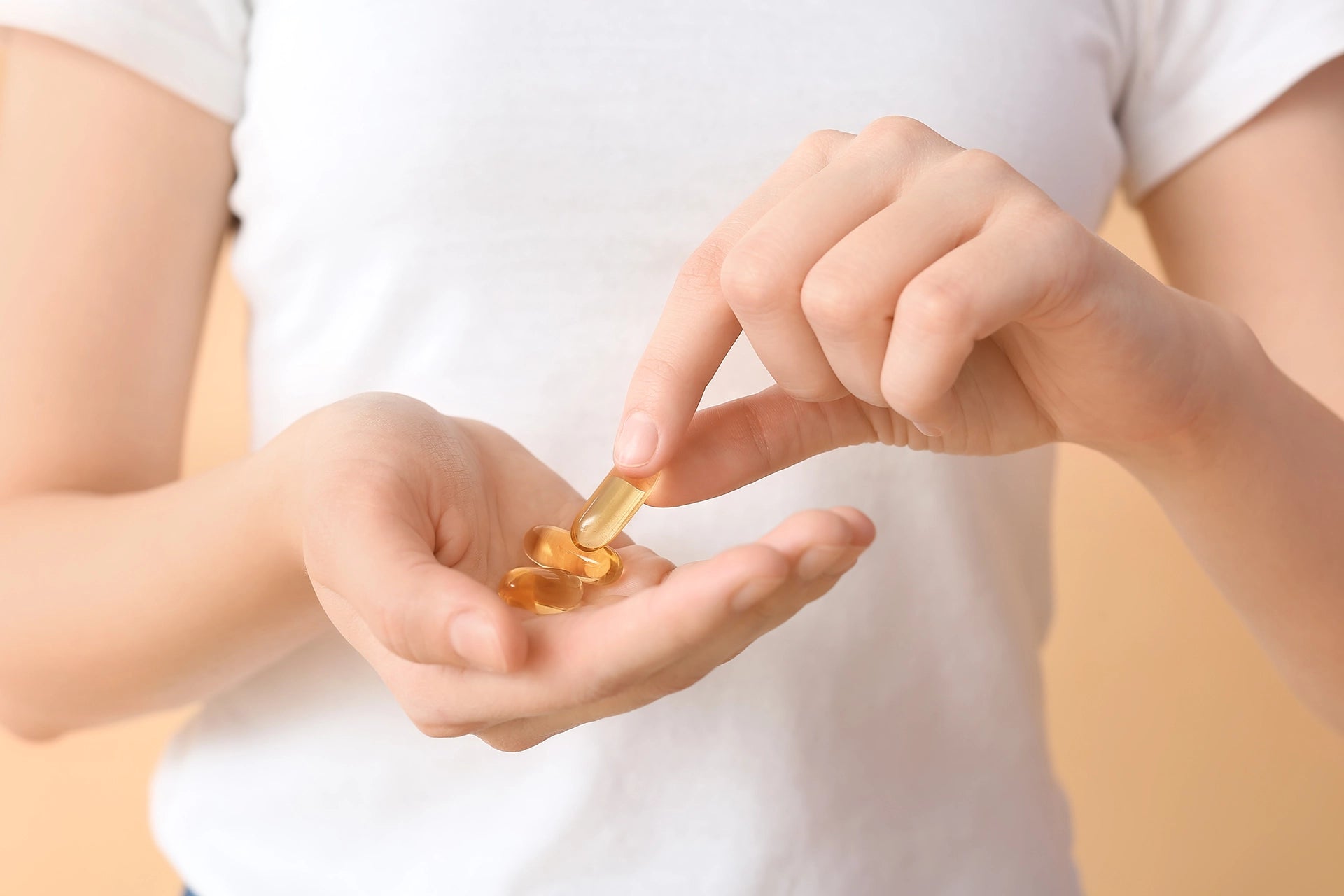 Person holding fish oil capsules