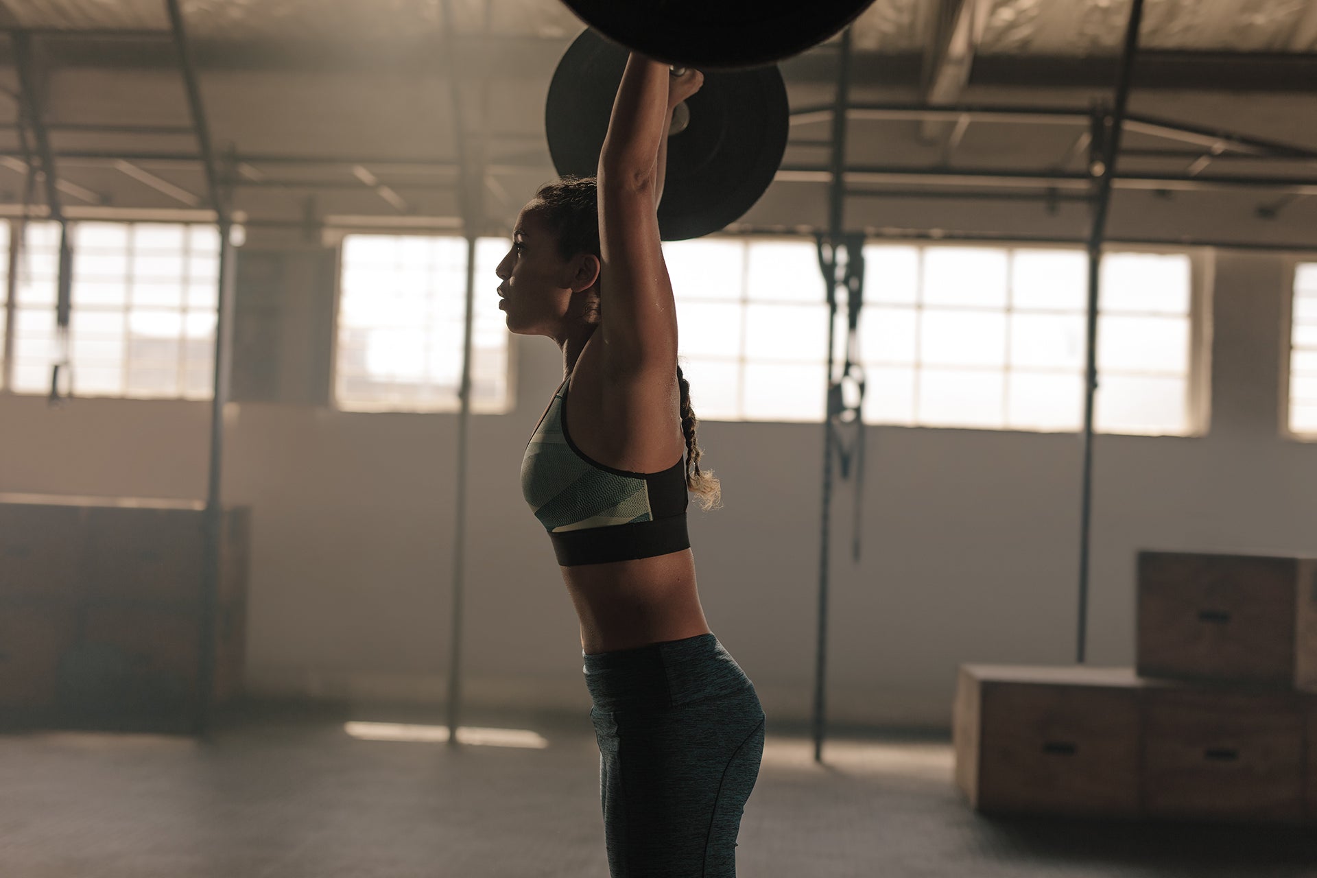 Woman doing overhead press in gym