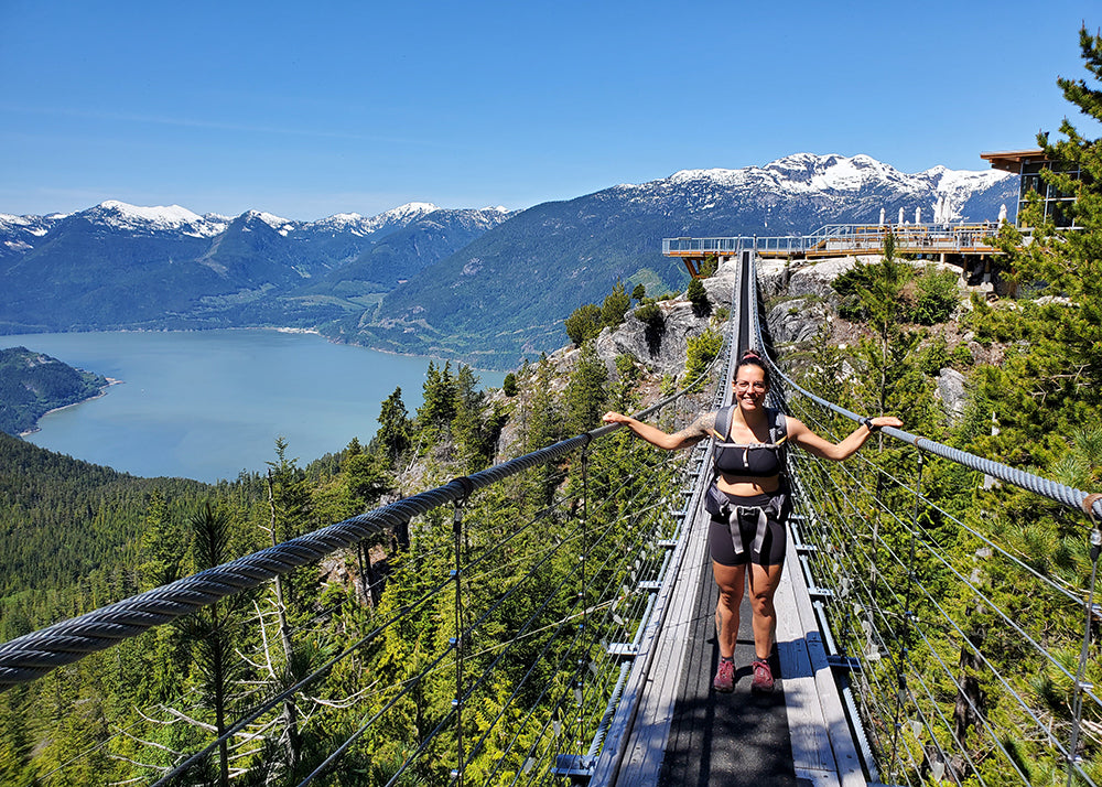 Ali Becker post trip blues tips - on a bridge over trees with a lake in the distance