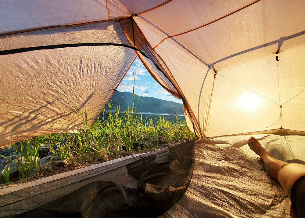 how to improve your sleep on trail - view of sunrise from inside a tent
