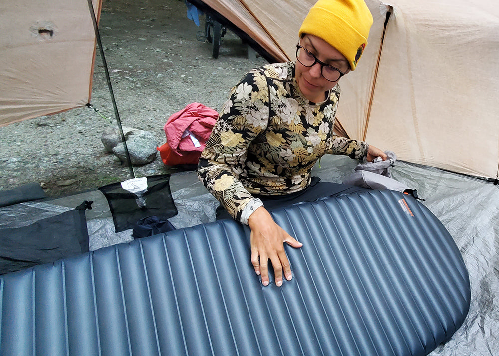 Ali examining her sleeping pad inside her tent