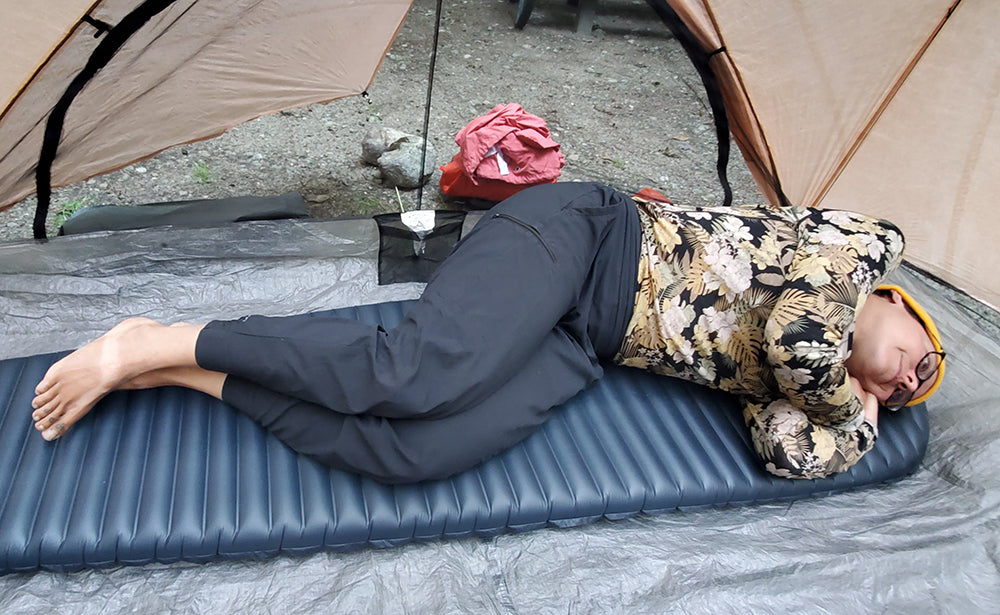 Ali sleeping on an inflatable sleeping pad in her tent