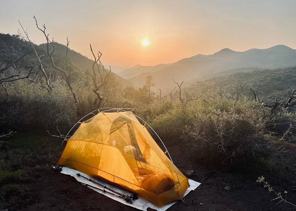 Big Agnes tent with a sunset behind it and mountains!